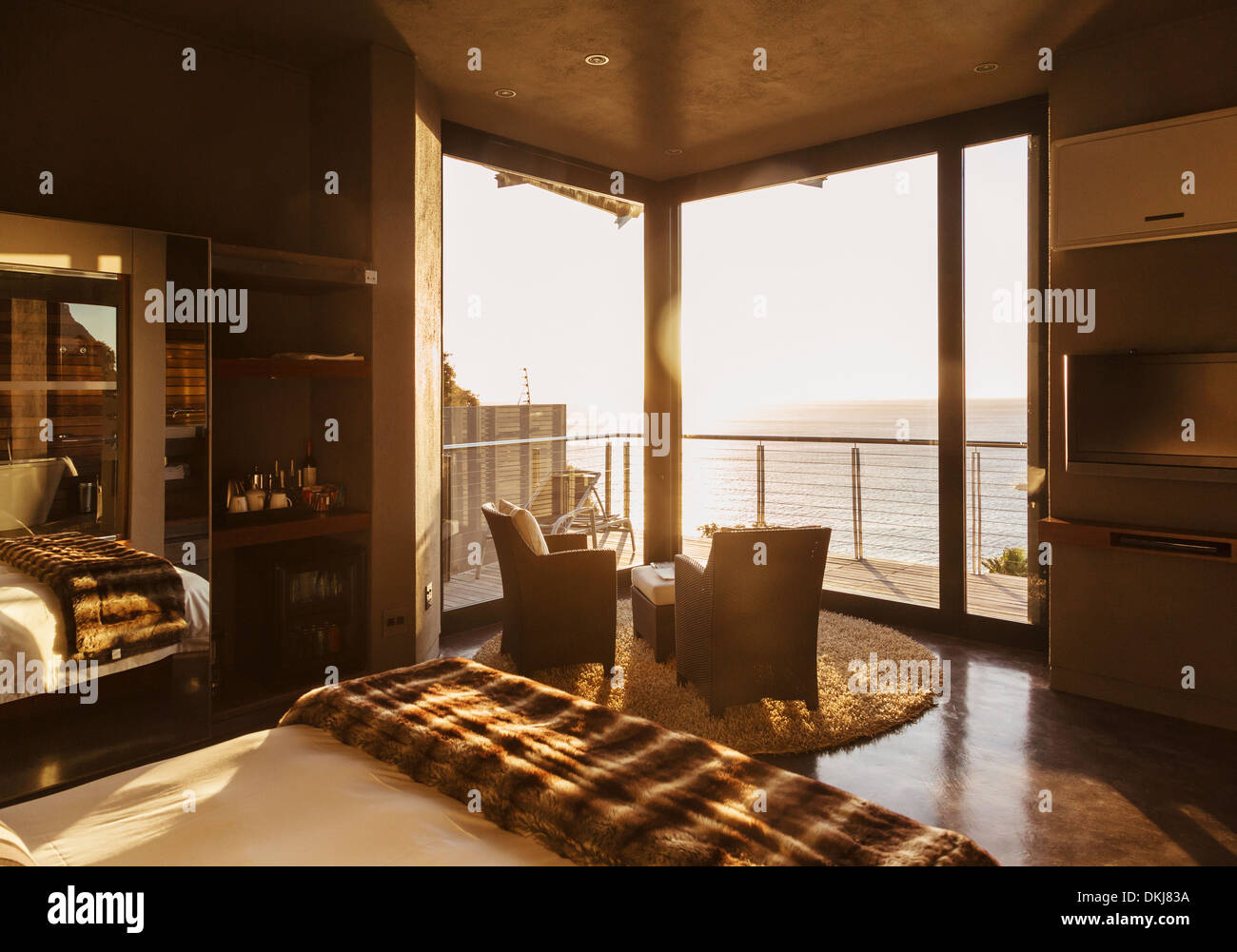 Luxury bedroom overlooking ocean at sunset Stock Photo Alamy