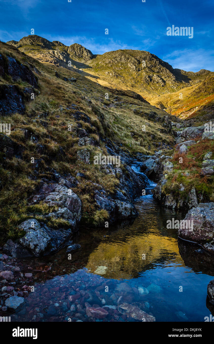 Waterfall leading up Hell Ghyll towards Crinkle Crags above and Bowfell (out of sight) Stock Photo