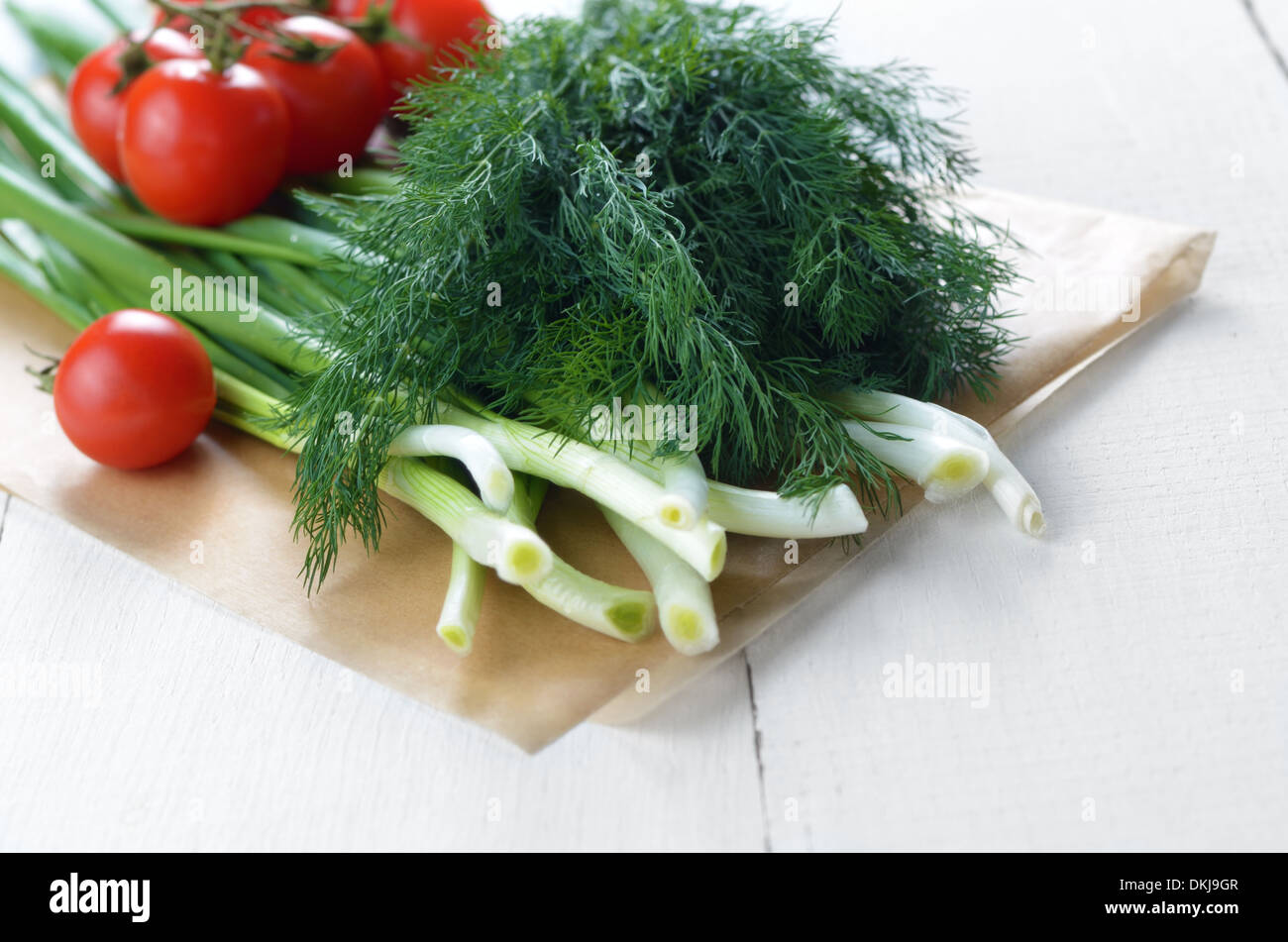 Fresh organic vegetable set of tomatoes dill and onion on white kitchen ...