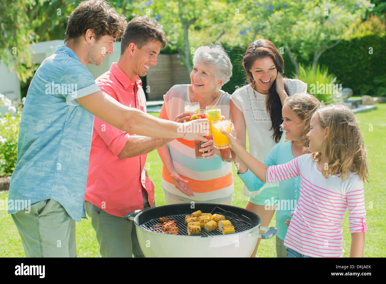Family toasting each other at barbecue Stock Photo