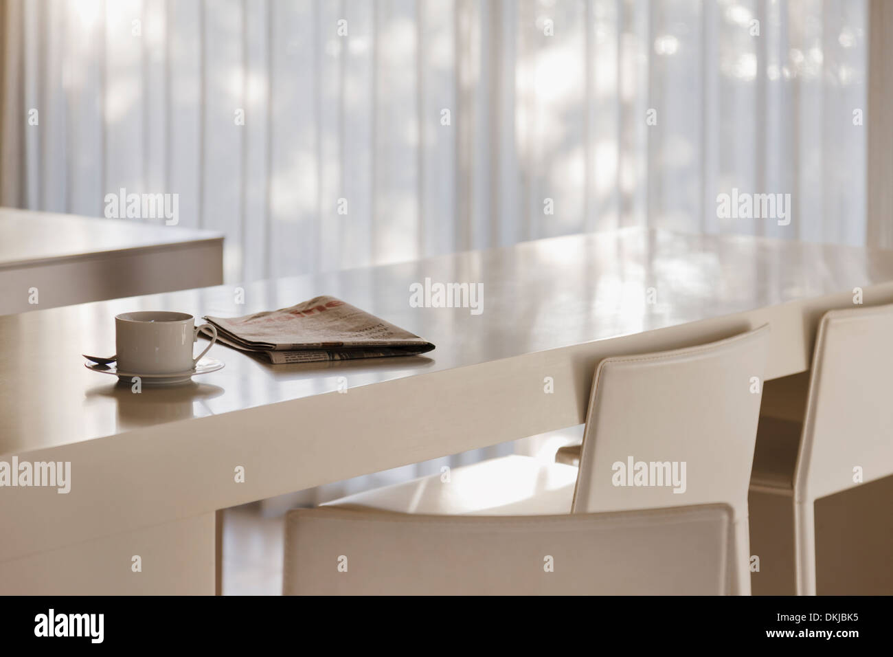 Coffee and newspaper on breakfast bar in modern kitchen Stock Photo