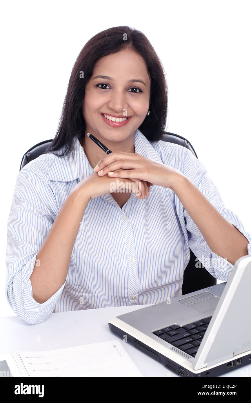 Smiling young business woman working with laptop against white Stock Photo