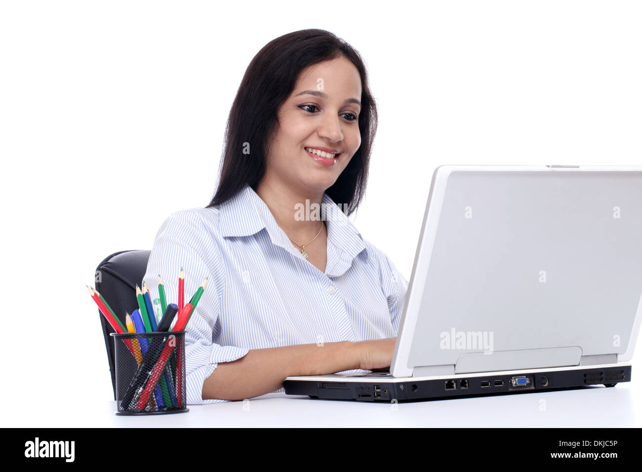 Smiling young business woman working with laptop against white Stock Photo