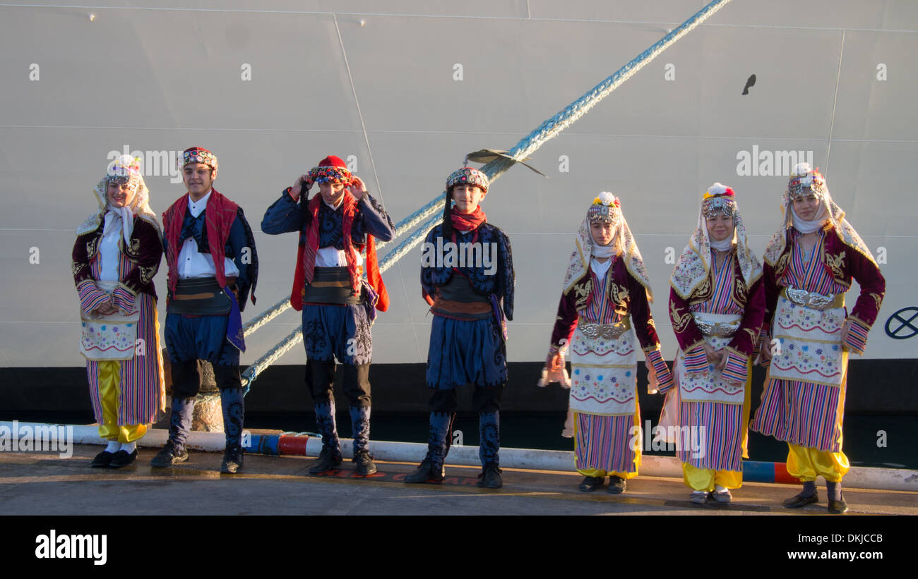 Turkish children in traditional costume waiting to greet passengers disembarking cruise ship in the port of Kusadasi, Turkey. Stock Photo