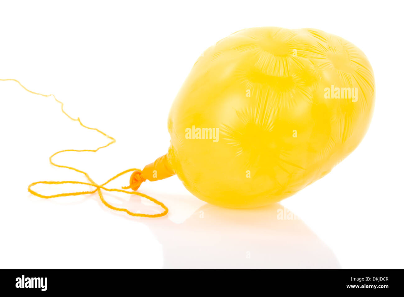 Deflated yellow balloon at a rope; isolated over white Stock Photo