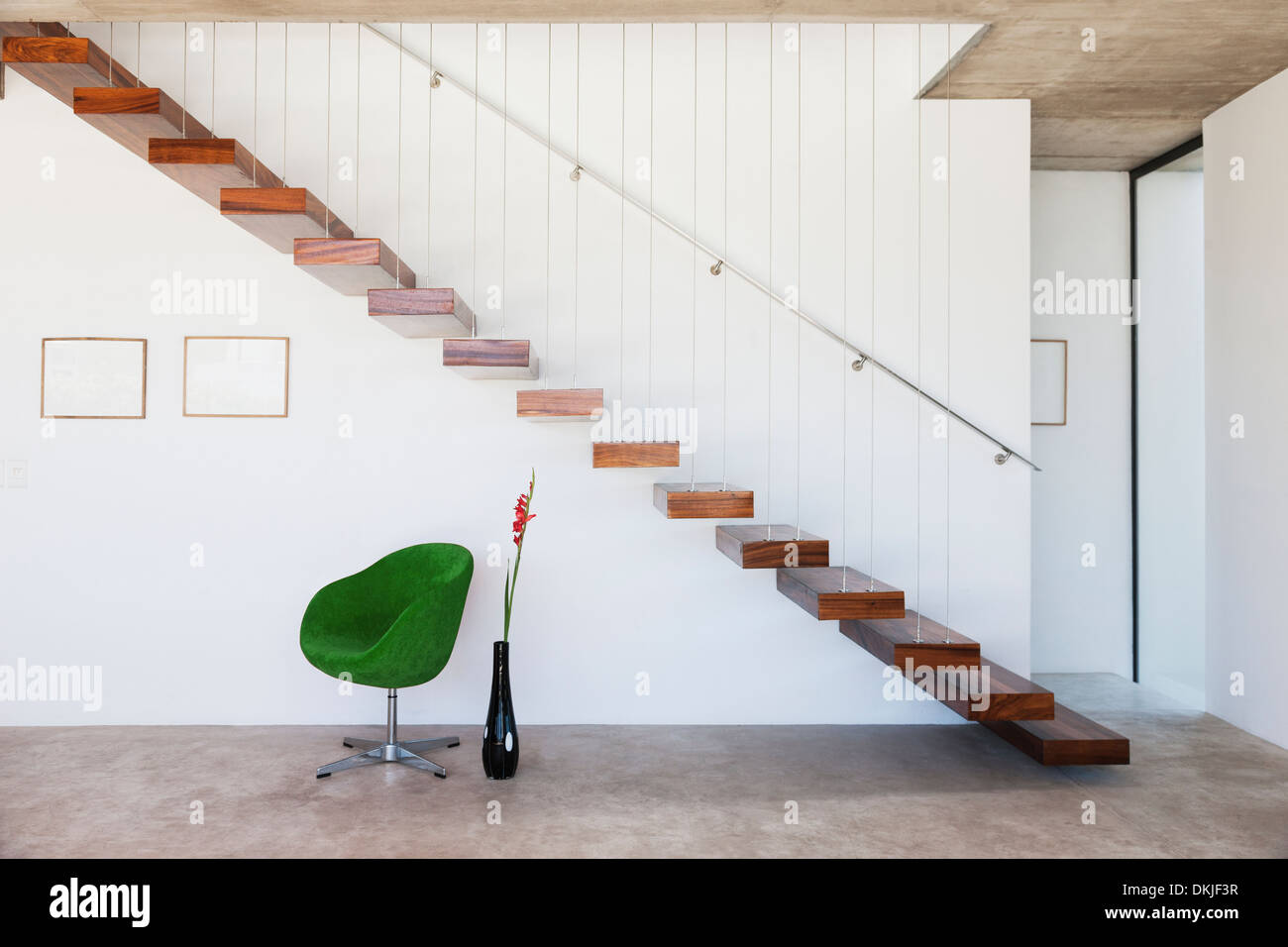Chair under floating staircase in modern house Stock Photo