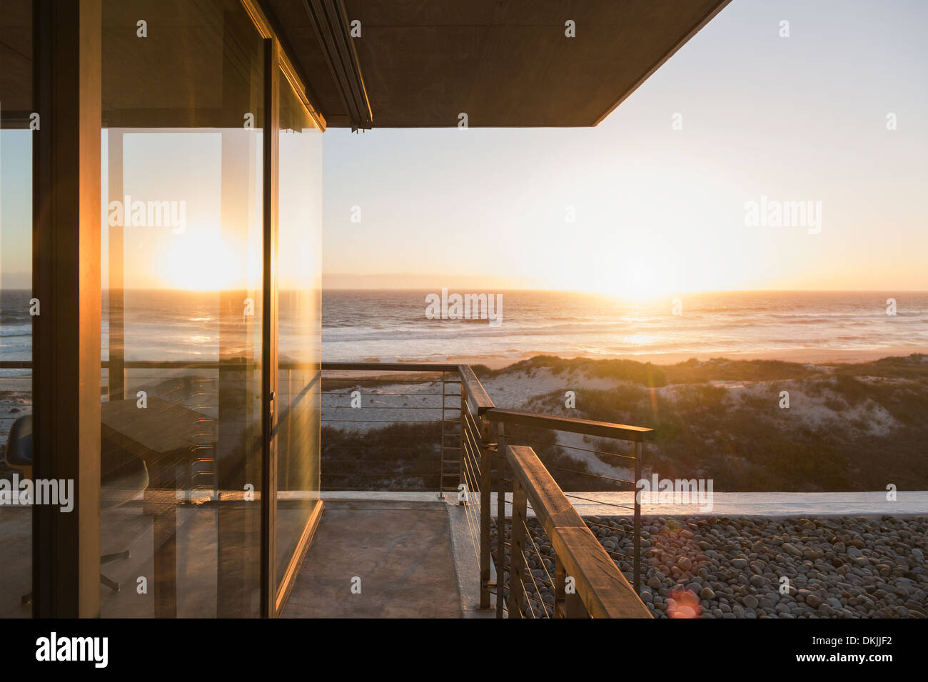 View of sunset over ocean from balcony of modern house Stock Photo