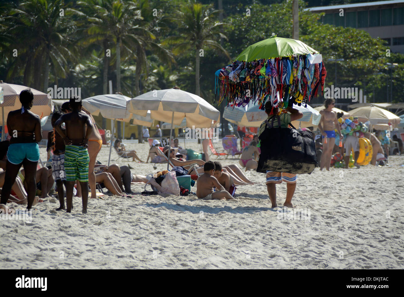 A beach hawker carrying his umbrella full of Brazilian bikinis for sale