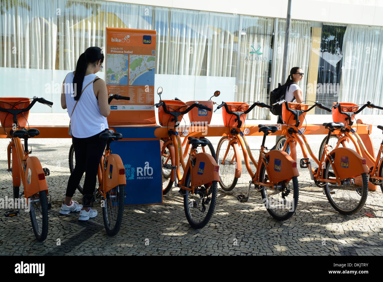 A girl selects a rent-a-bicycle from a bike stand on Copacabana Beach ...