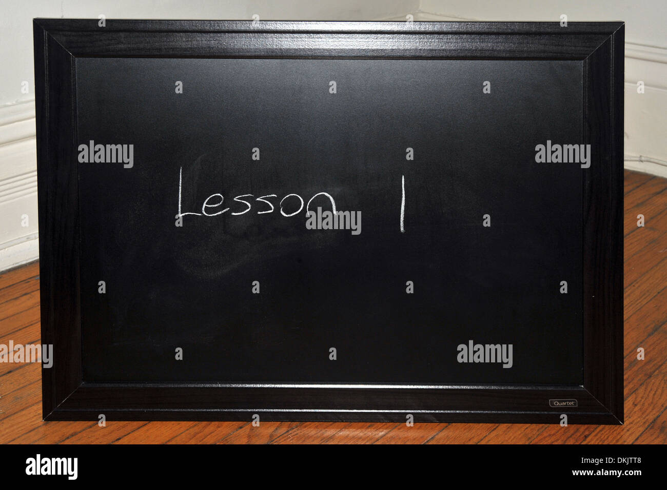 A blackboard with the word lesson 1 written on it in white chalk Stock
