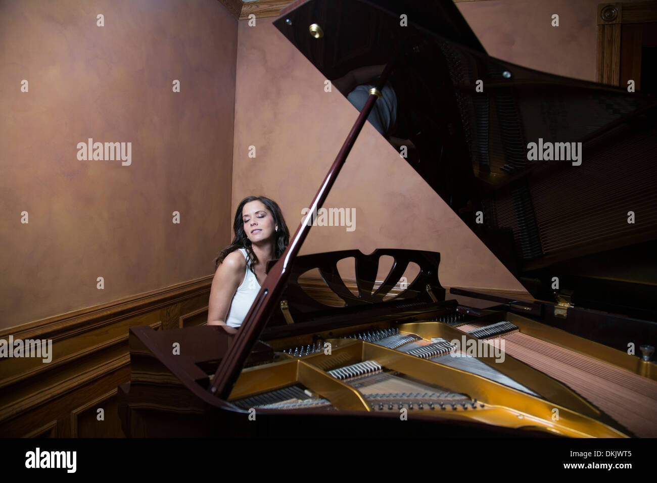Woman playing a grand piano Stock Photo