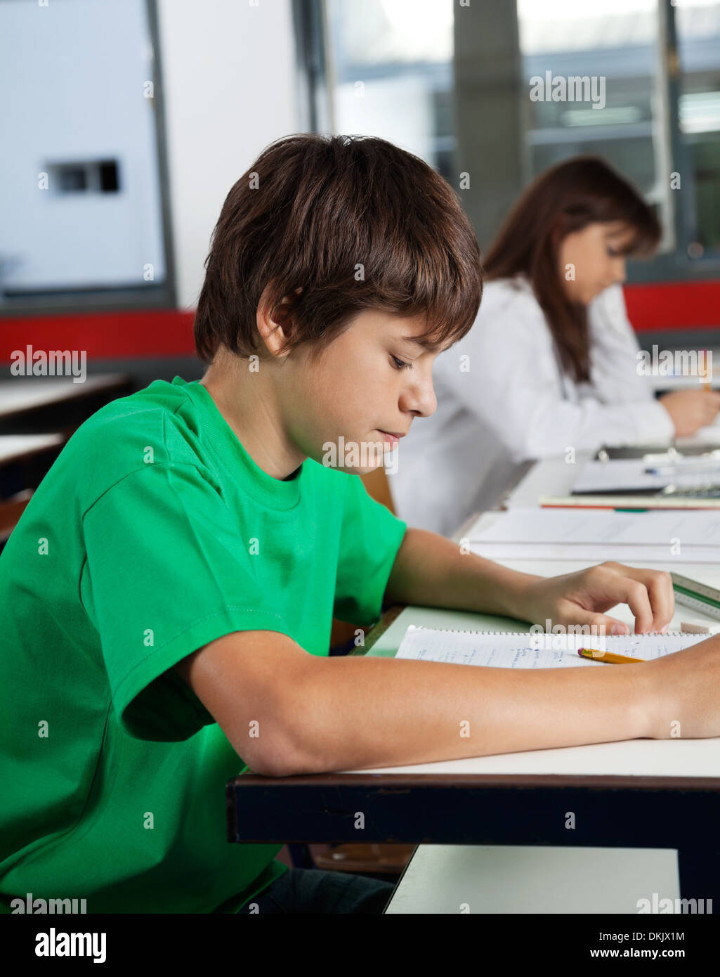 Schoolboy Studying At Desk In Classroom Stock Photo - Alamy
