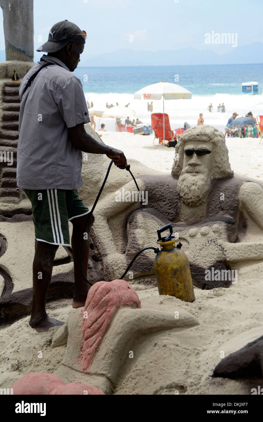 A sand sculpture using a gas torch, modelling his sculpture on Copacabana beach in Rio de Janeiro, Brazil Stock Photo