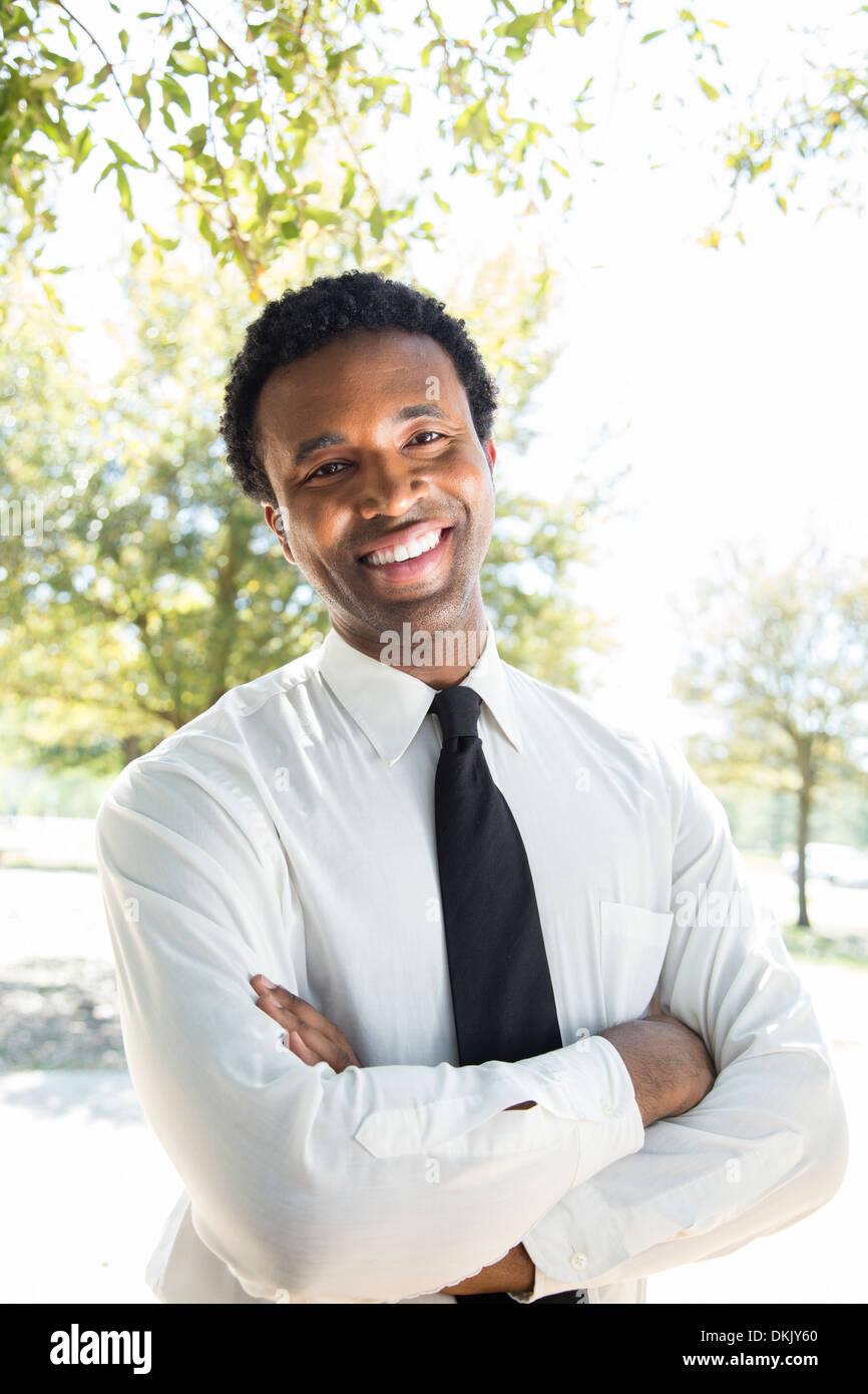 Smiling young business man with arms folded Stock Photo