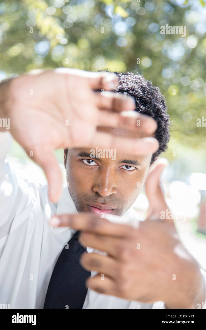 Professional young man finger-framing at the park Stock Photo