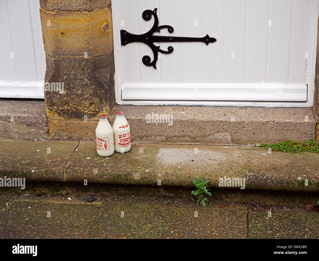 Two bottles of milk on the doorstep of a historic house in Corbridge, Northumberland Stock Photo