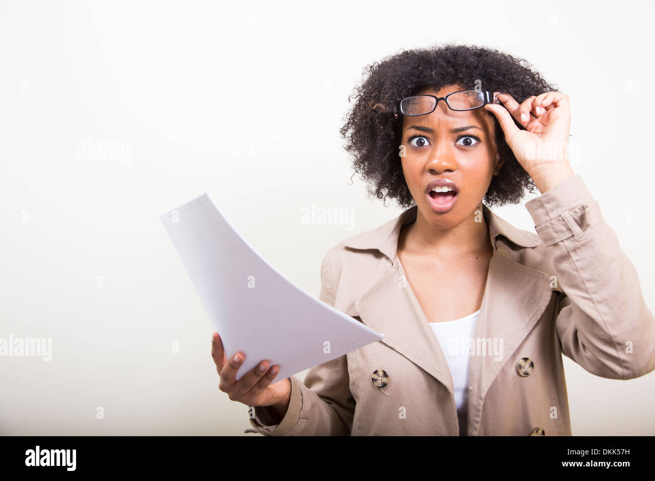 African American woman holding papers looking shocked Stock Photo