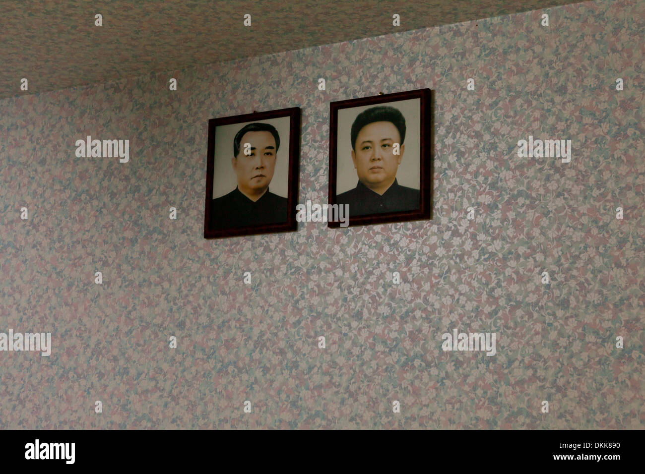 Mock-up of North Korean family home interior displaying portraits of Kim Il Sung and Kim Jong Il on wall Stock Photo