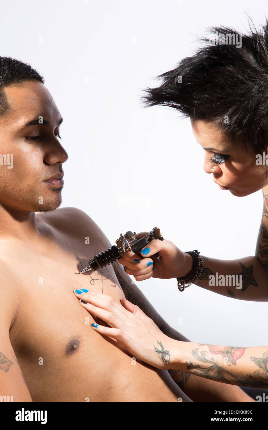 Man getting tattoo from woman Stock Photo