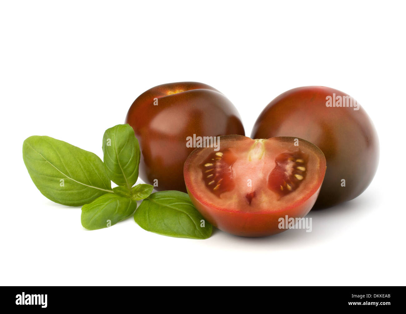 Tomato kumato and basil leaf isolated on white background Stock Photo
