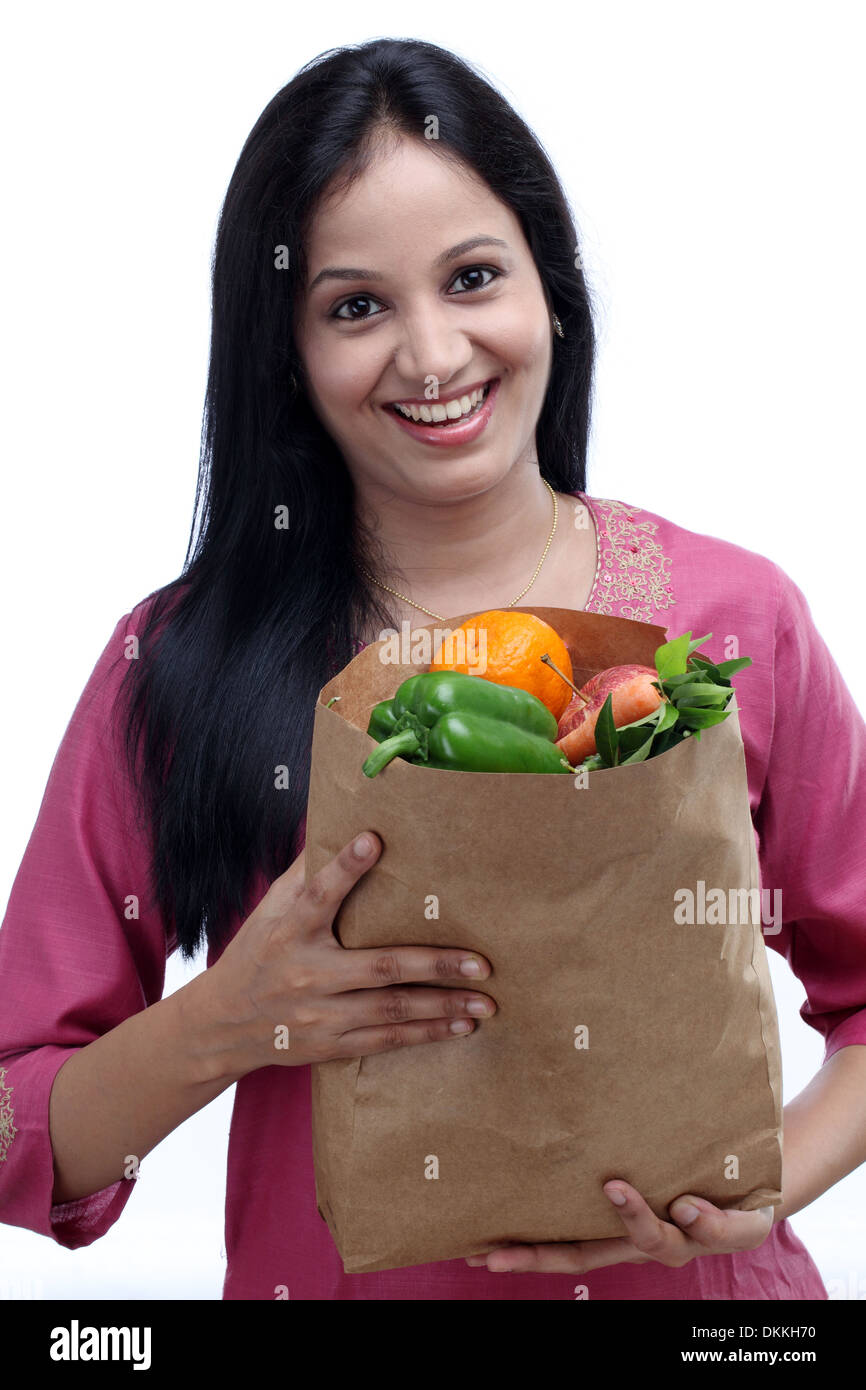Young Indian woman holding grocery bag with full of fruits and vegetables Stock Photo