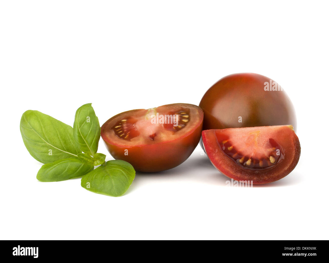 Tomato kumato and basil leaf isolated on white background Stock Photo