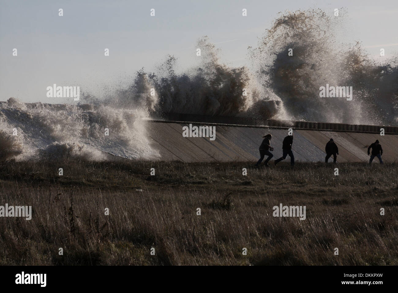 Lowestoft, UK. 6th Dec, 2013. Spectators flee as waves on a rogue tidal surge break over the sea wall in Lowestoft near North Deanes Caravan Park, on Friday Dec 6 2013. A combination of high tides and the worst tidal surge in 60 years has been causing flooding and evacuation across the east of England - Lowestoft is the most easterly point of the UK. Credit:  Solveig Stibbe/Alamy Live News Stock Photo