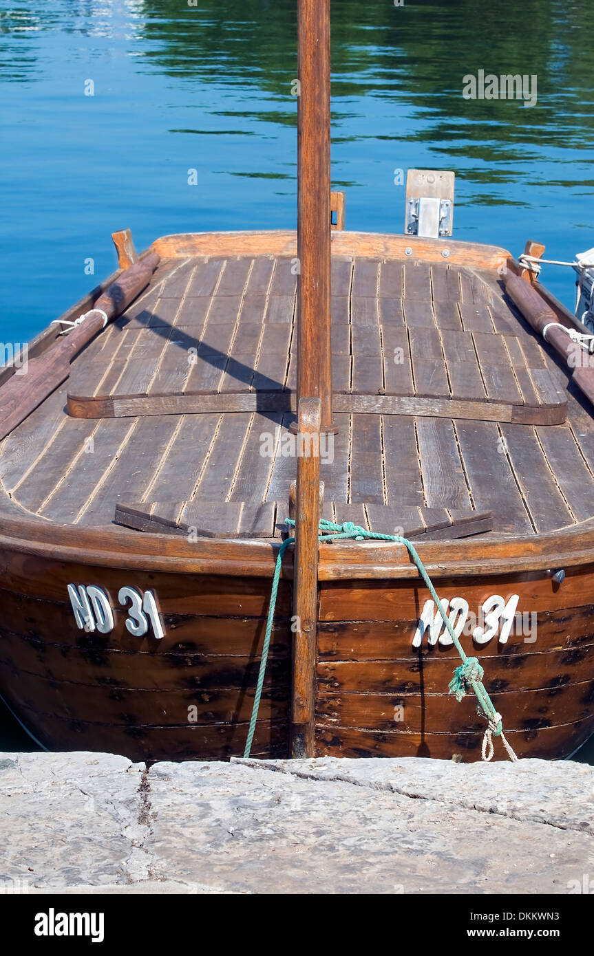 Old wooden boat docked to stone pier Stock Photo - Alamy