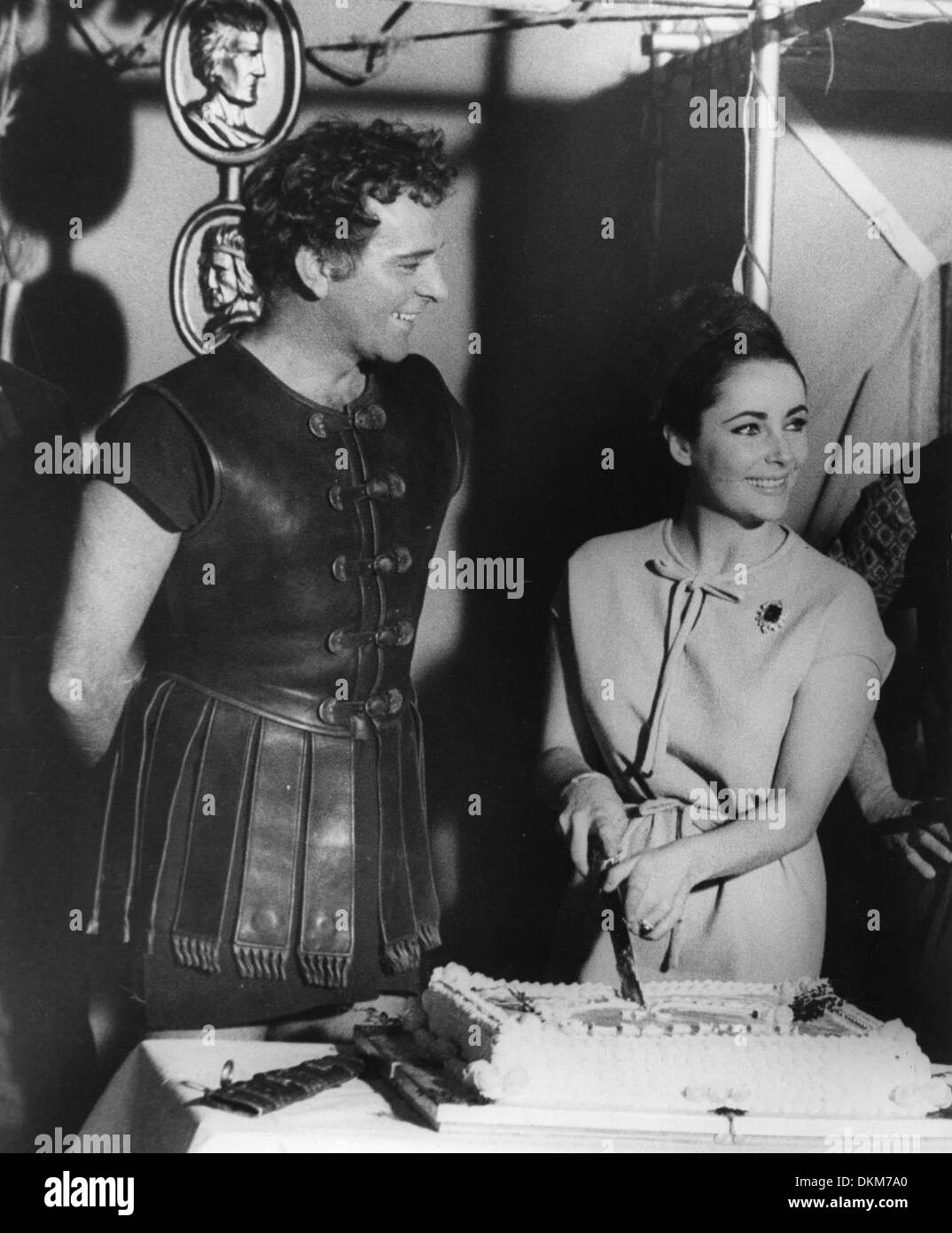 Feb. 28, 1963 - London, England, U.K. - Academy Award winning film legend ELIZABETH TAYLOR celebrated her 31st birthday at Pinewood Studios, with her husband RICHARD BURTON. PICTURED: Liz Taylor cuts the cake with a gladiator sword. (Credit Image: © KEYSTONE Pictures USA) Stock Photo