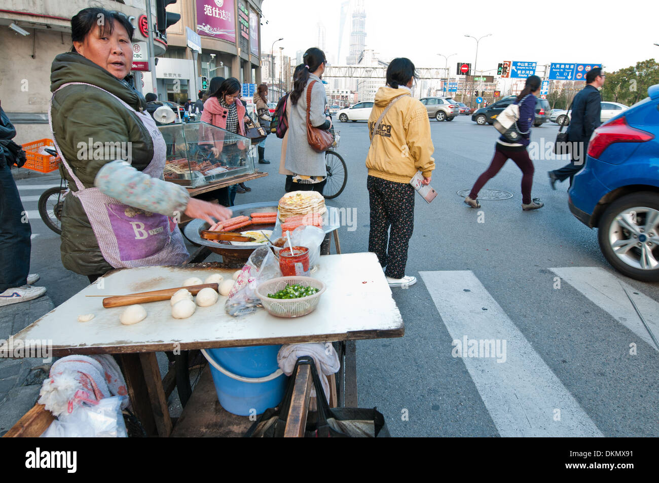 Woman selling sausages on busy Renmin Road  in Shanghai, China Stock Photo