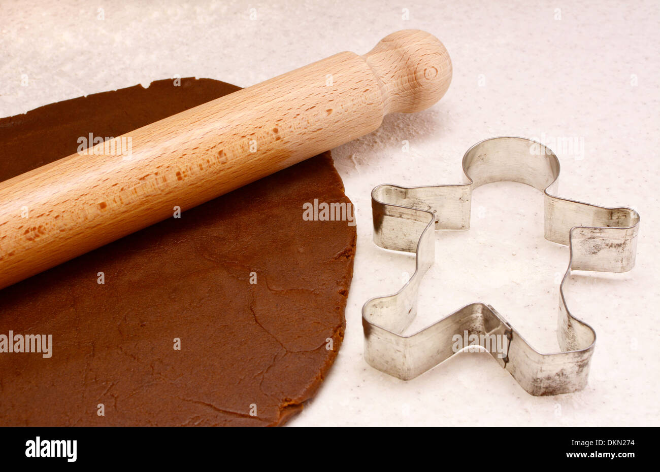 Gingerbread dough, wooden rolling pin and gingerbread man cookie cutter