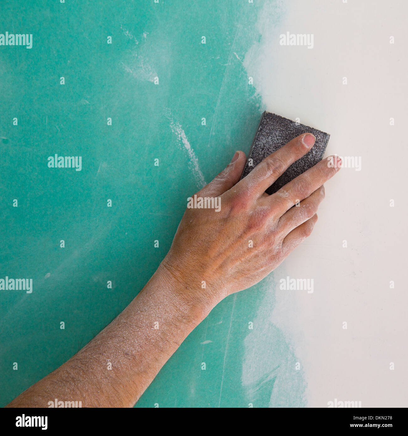 plastering man hand sanding the plaste in drywall seam plasterboard