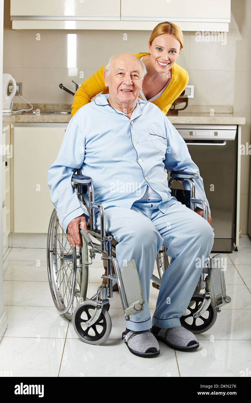 Demented senior man in wheelchair with extended care assistant Stock Photo