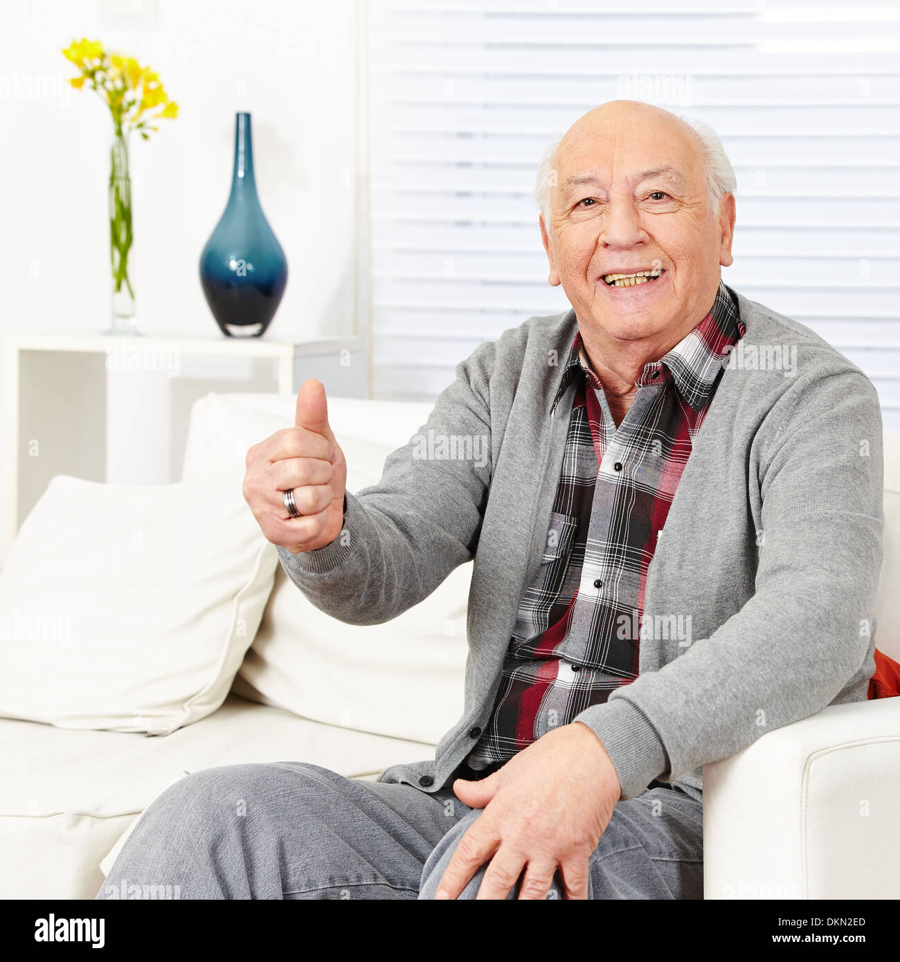 Old happy man holding thumbs up in a retirement home Stock Photo