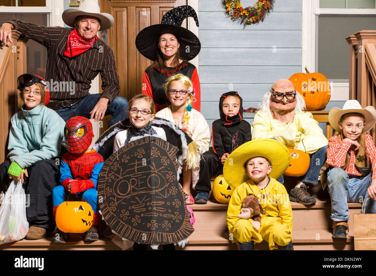 Family of parents and three children dressed in costume for Halloween Trick-or-Treating Stock Photo