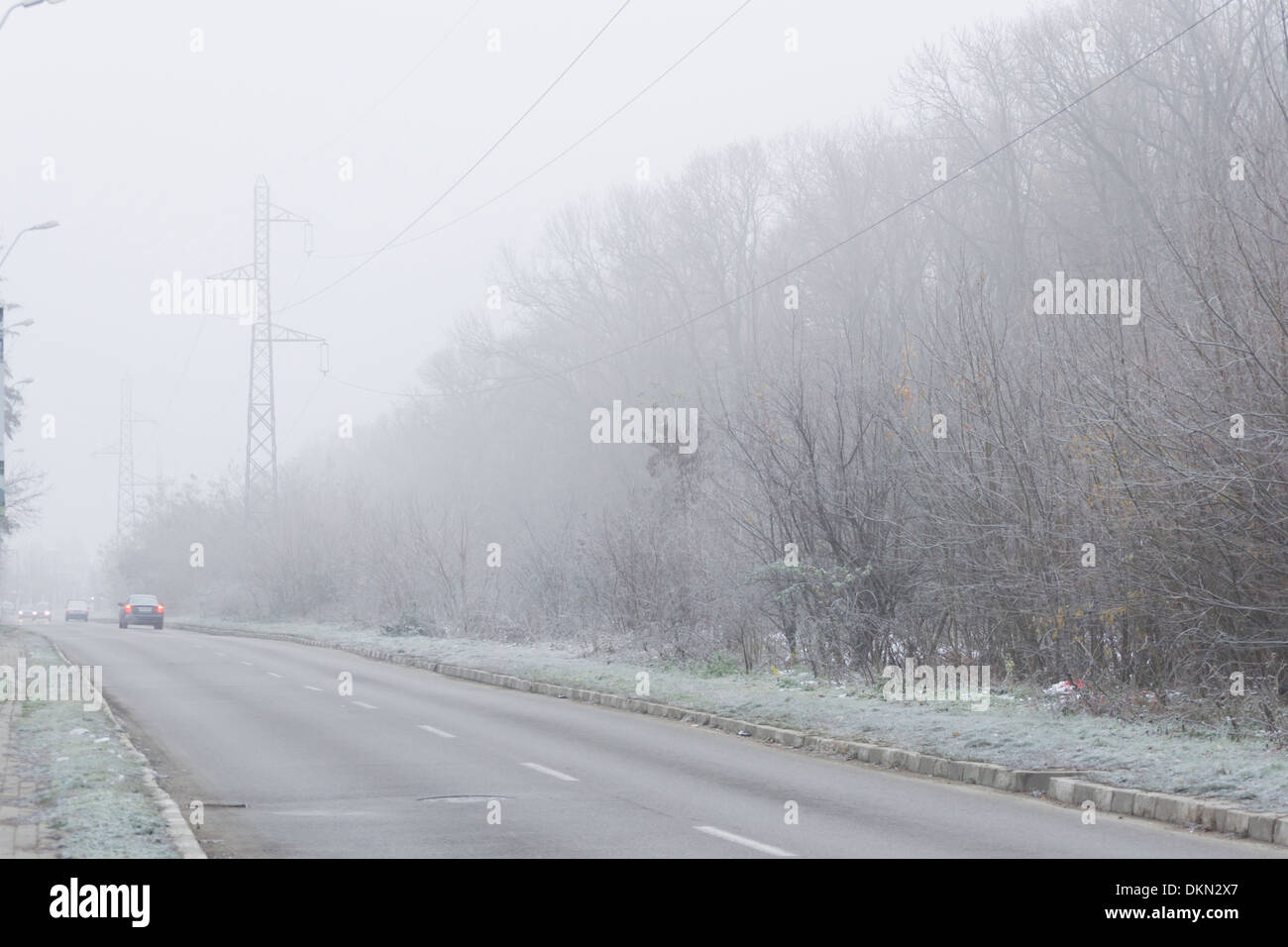 Road with electricity pylons in the background in winter Stock Photo ...