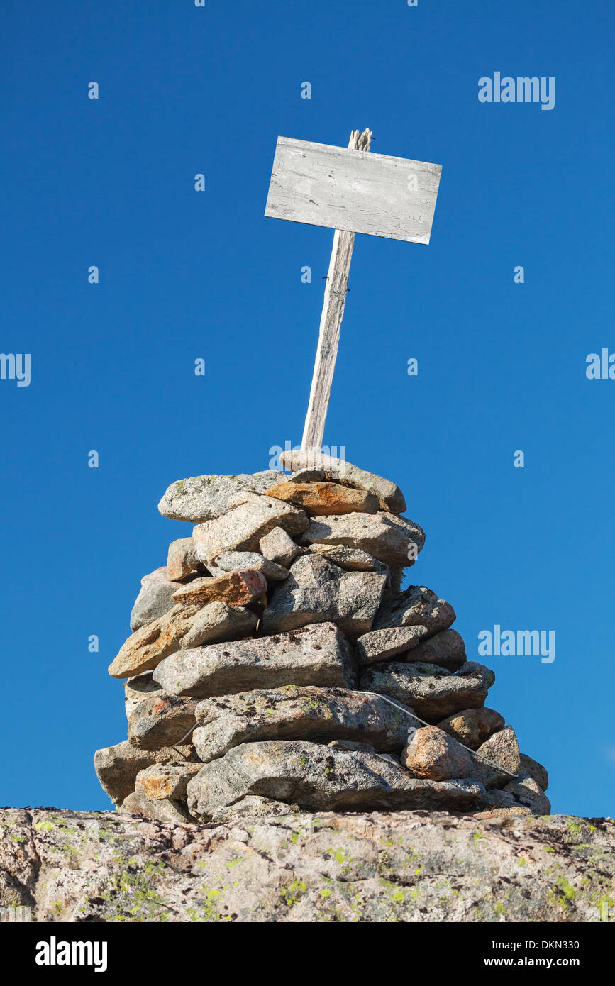 Stone cairn with empty white wooden label Stock Photo