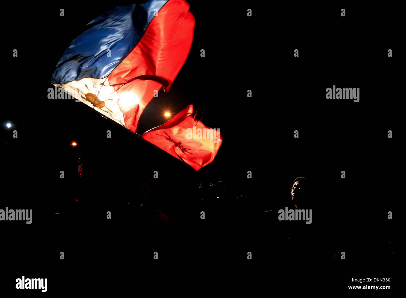 Manila, Philippines. 6th Dec, 2013. A man waves the Philippine flag in Quezon City, north of Manila, with the flag of the Philippine revolution.Photo: J Gerard Seguia/NurPhoto Credit:  J Gerard Seguia/NurPhoto/ZUMAPRESS.com/Alamy Live News Stock Photo