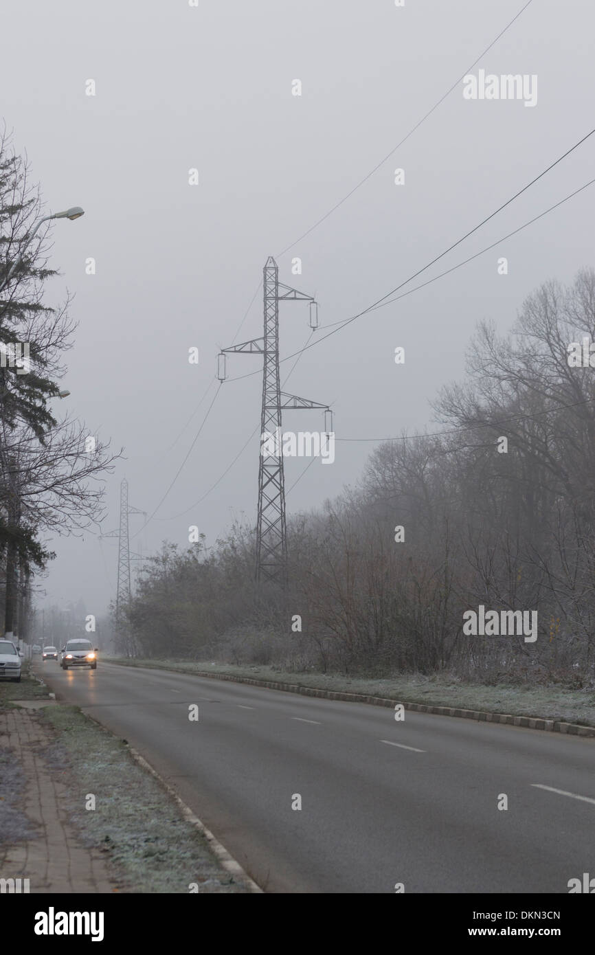 Road with electricity pylons in the background in winter Stock Photo ...