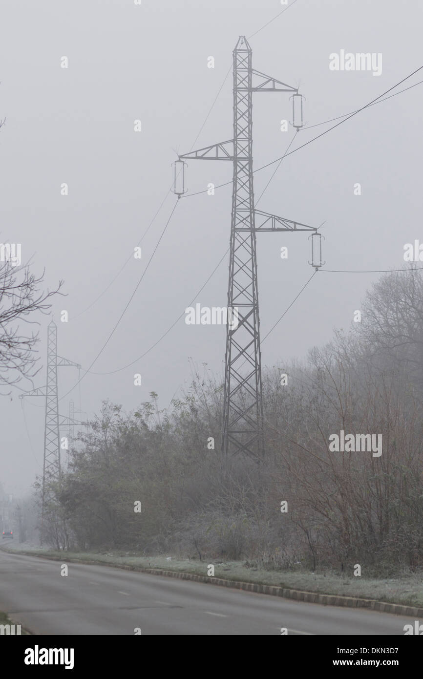 Road with electricity pylons in the background in winter Stock Photo ...