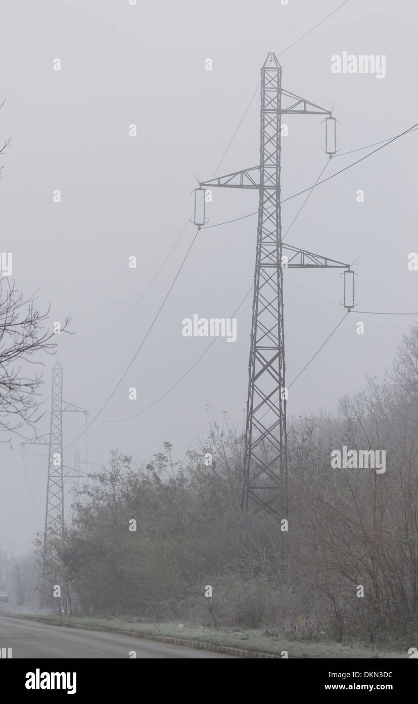 Road with electricity pylons in the background in winter Stock Photo ...