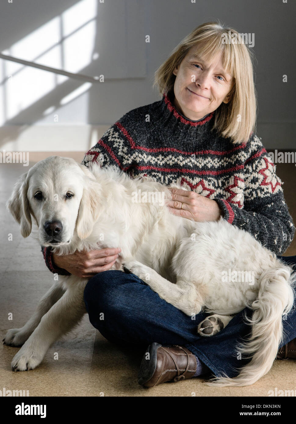 Portrait of woman with her six month old Platinum colored Golden Retriever Dog Stock Photo