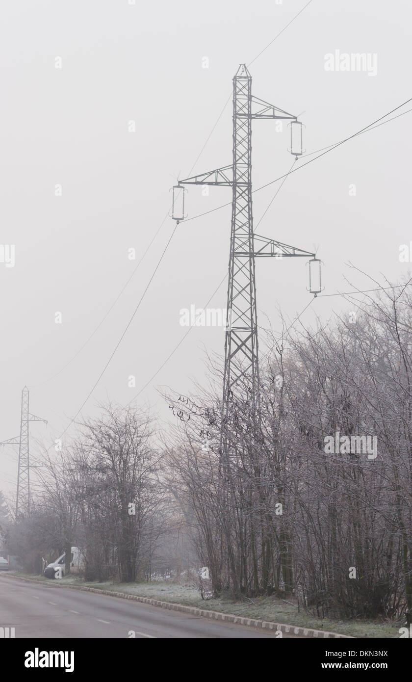 Road with electricity pylons in the background in winter Stock Photo ...