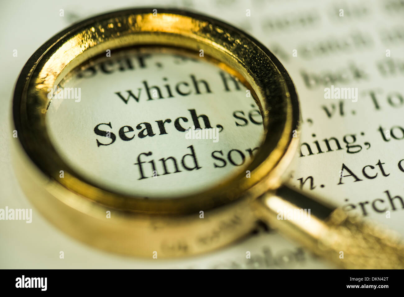 Macro Image Of A Magnifying Glass Over The Search Word In A Dictionary