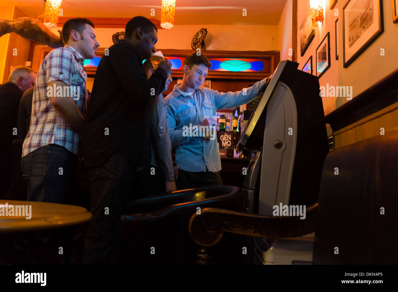 A group of young men playing on a quiz machine in the Castle Hotel pub, Aberystwyth UK Stock Photo