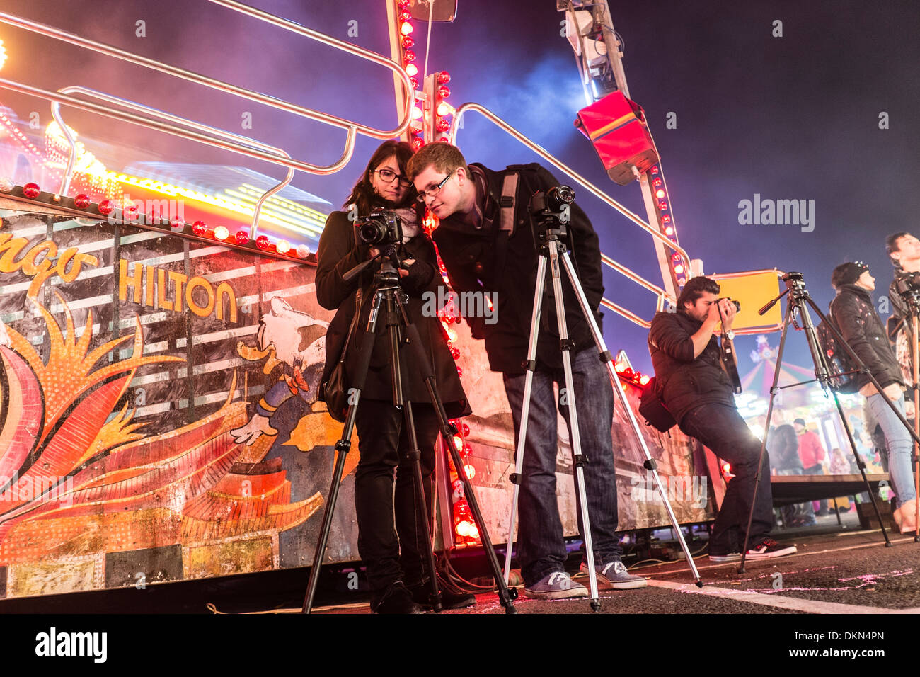 A group of college photography students photographing the rides at Aberystwyth funfair, Wales UK Stock Photo