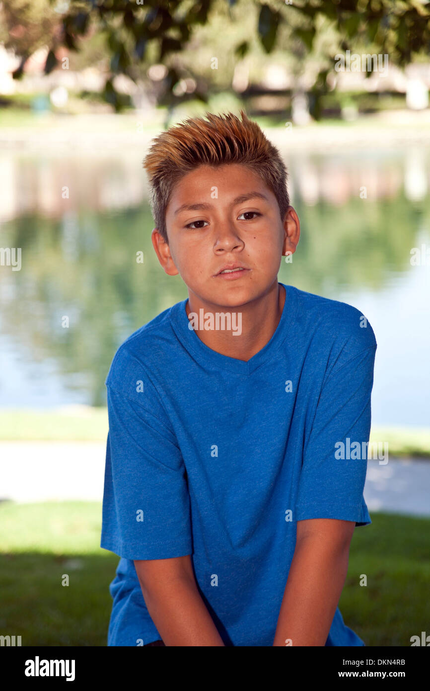 Portrait 11-13 years old serious multi racial diversity racially diverse multicultural cultural teenage Hispanic boy in park. MR © Myrleen Pearson Stock Photo