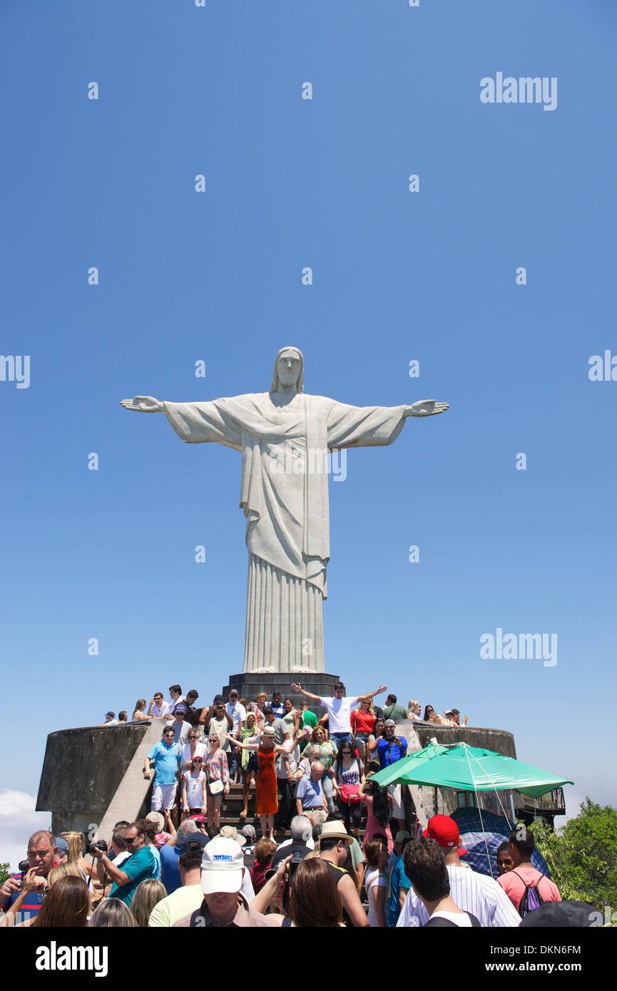 Crowds of tourists visit the Christ monument at Corcovado posing with outstretched arms Rio de Janeiro Brazil Stock Photo