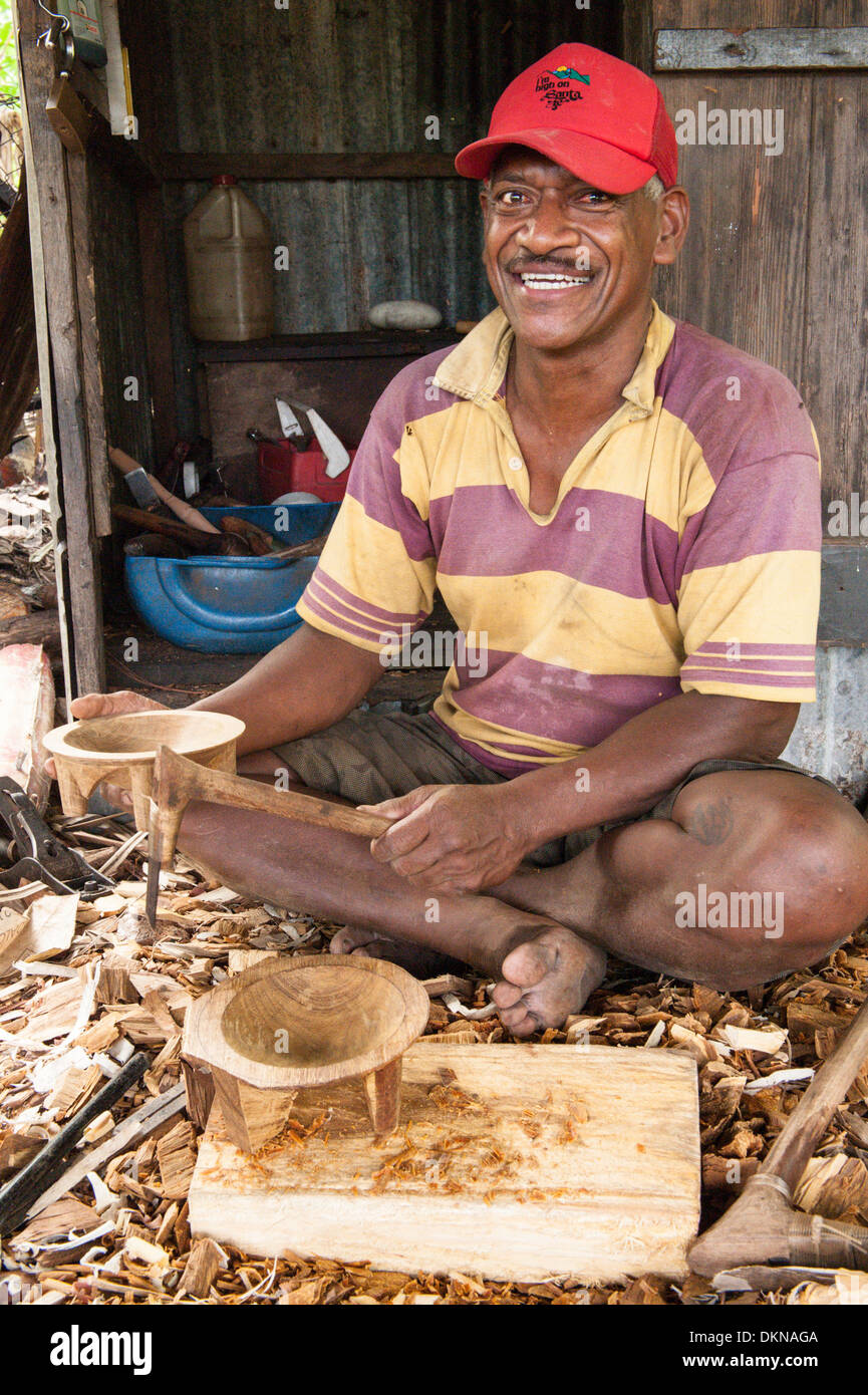 Nico, a wood carver, sitting holding a kava bowl, a tanoa, he has made of vesi. Village of Muanaicake, Fulaga, southern Laus, Fiji. Stock Photo