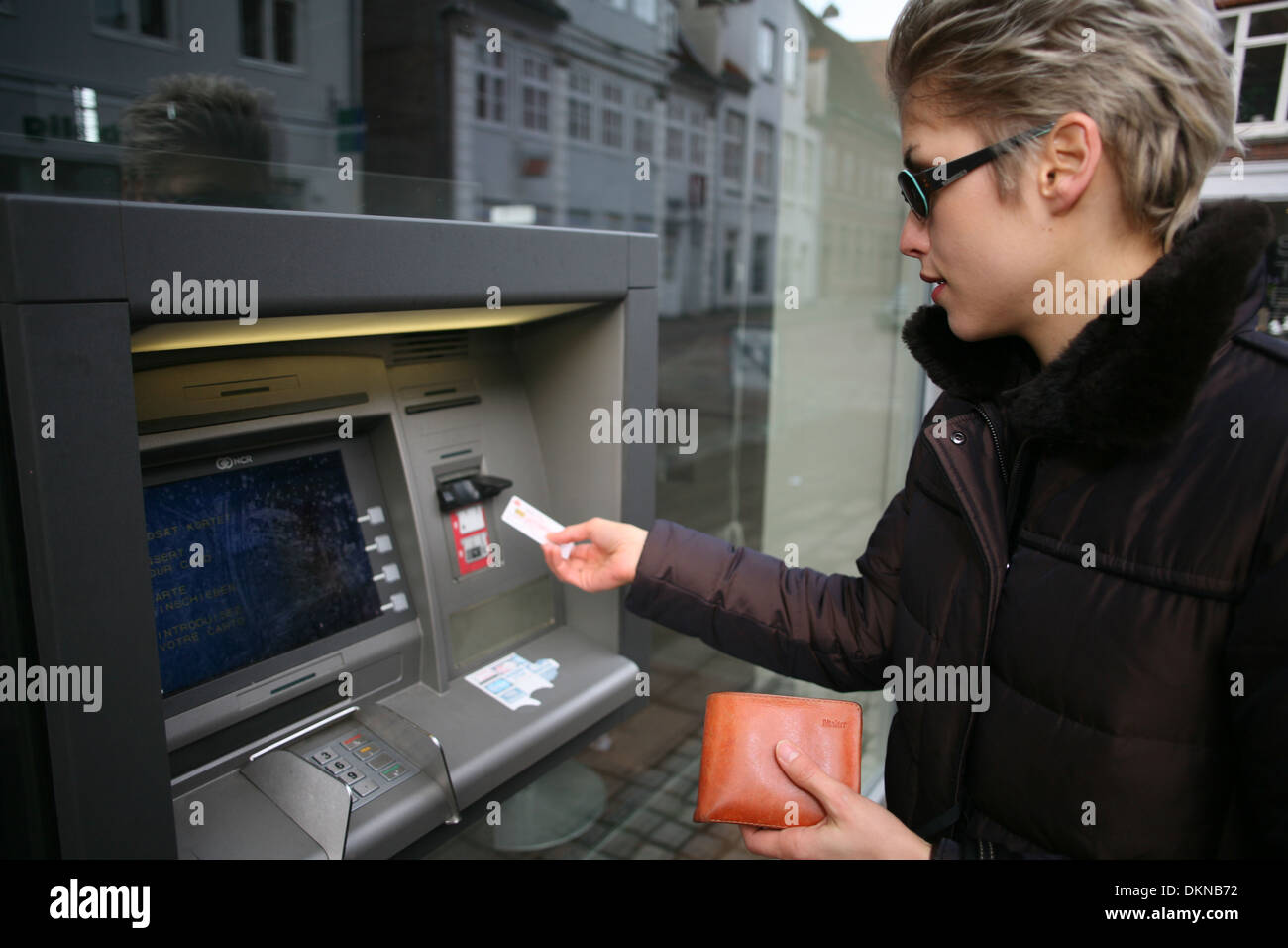 pretty woman outdoor taking cash from an atm machime Stock Photo